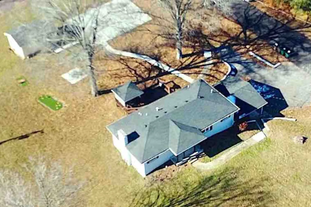 A relaxed view of the backyard featuring a deck, grassy play area, and the house in the background. The image showcases a space ideal for barbecues, family gatherings, and outdoor fun, with plenty of green space for pets and people alike.