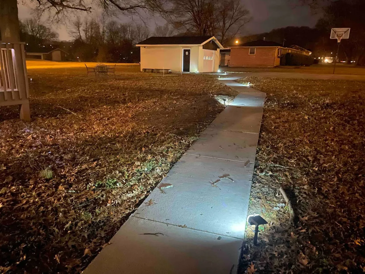 A peaceful exterior shot of a pathway leading through trees to a shed and a park bench, evoking the feel of a nearby nature trail or park. The calm, inviting atmosphere connects directly to the idea of local parks and nature exploration.